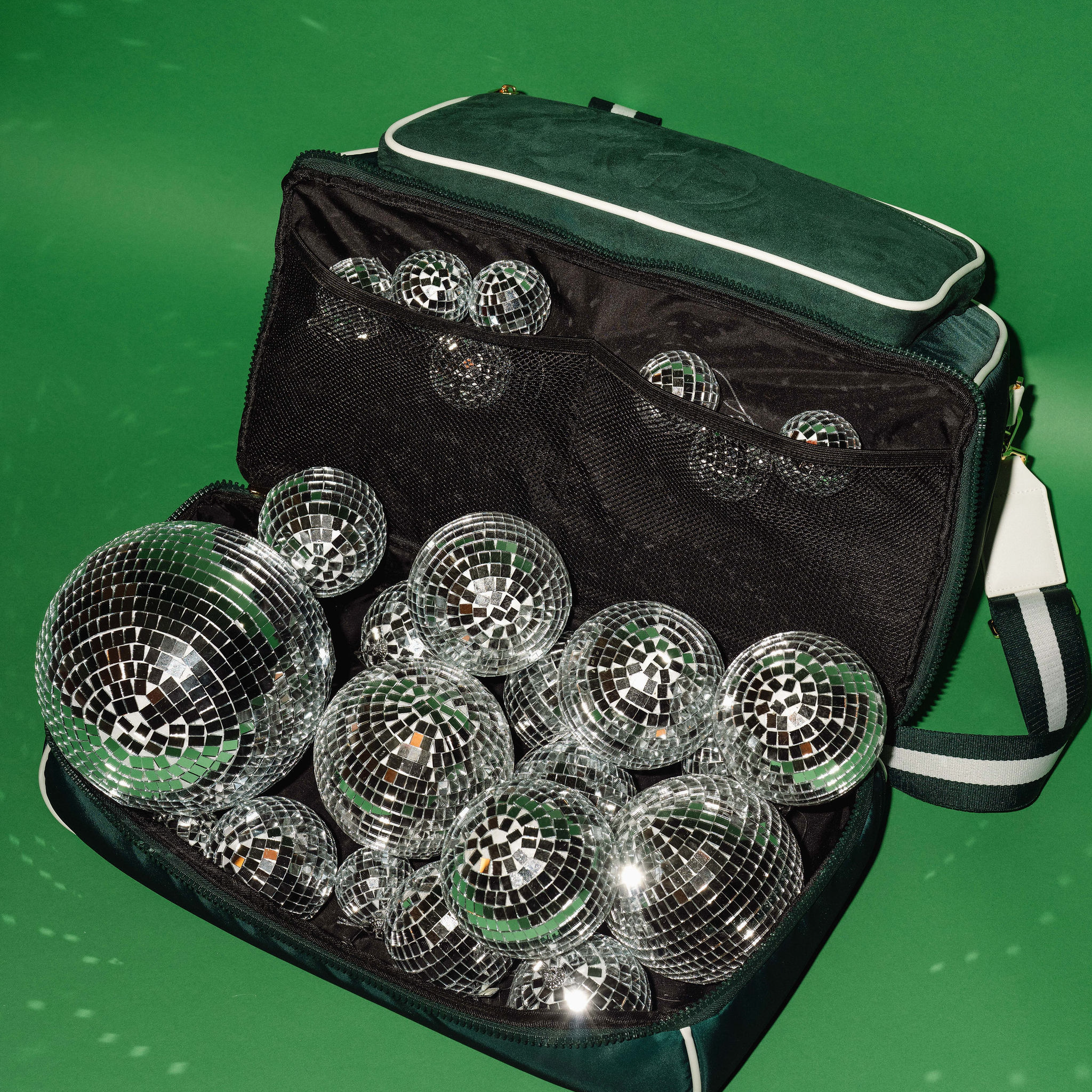 Green BoldAir Stayover Bag, a women's weekender bag, with the shoe compartment open to showcase organized storage and silver disco balls.